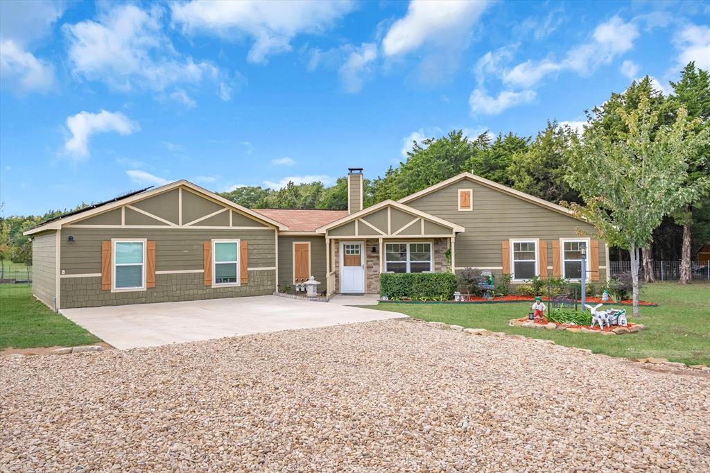 a front view of a house with a yard and trees