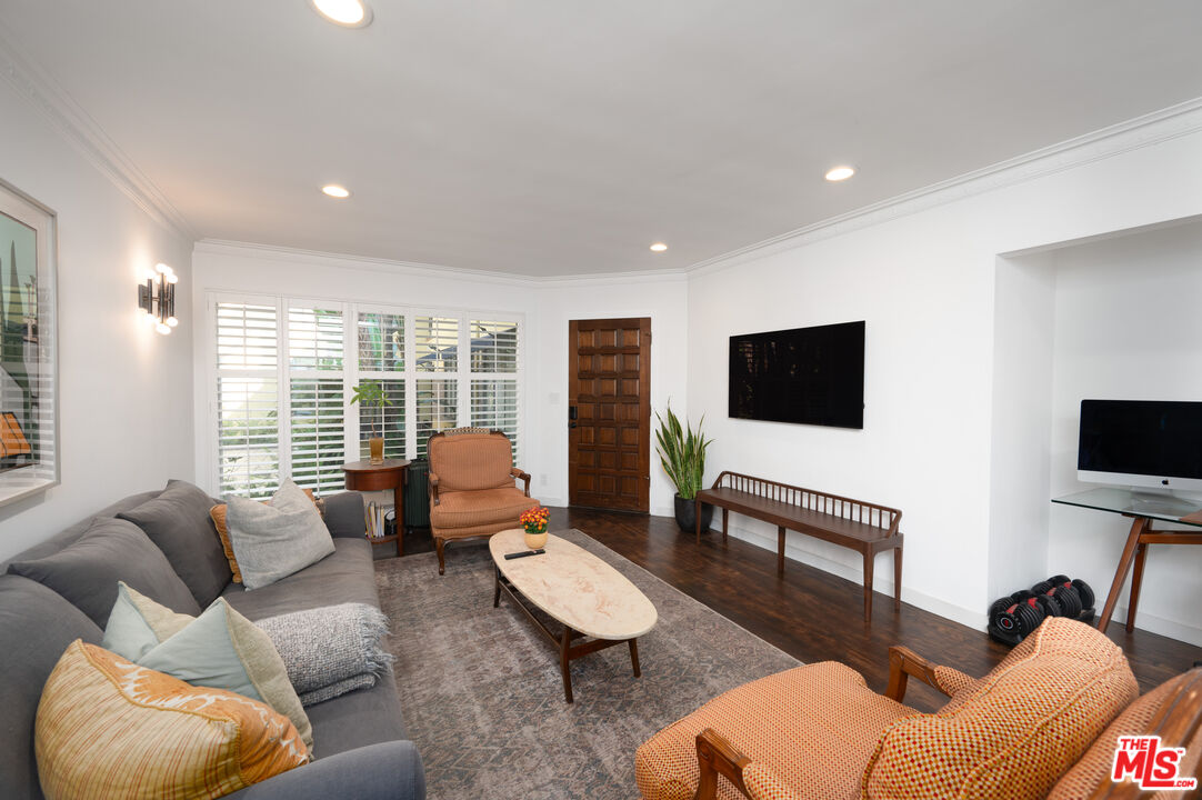 a living room with furniture a flat screen tv and a large window