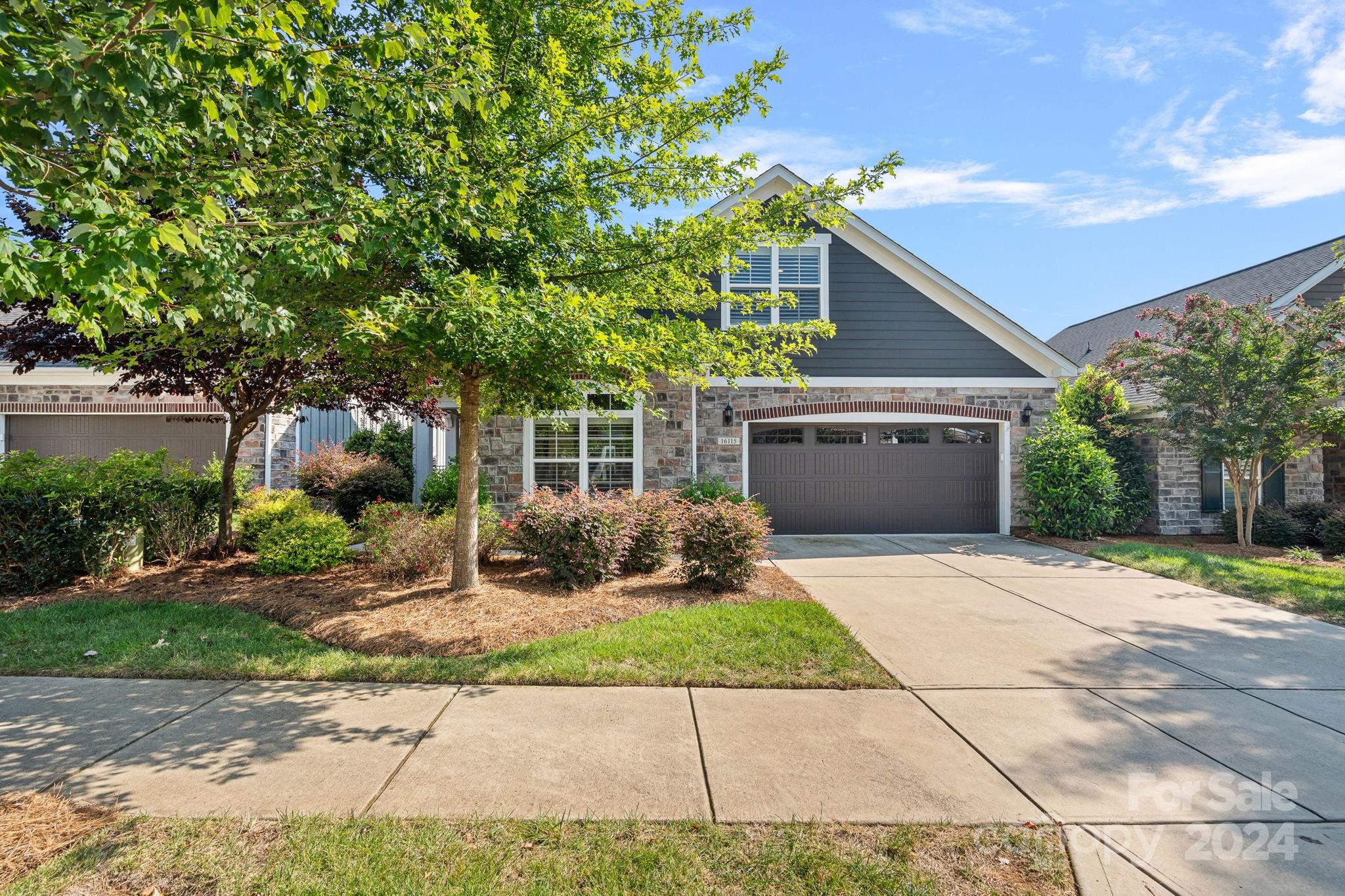 a front view of a house with a yard and a garage