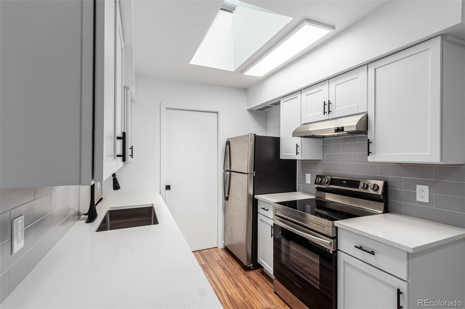 a kitchen with a sink a stove and refrigerator