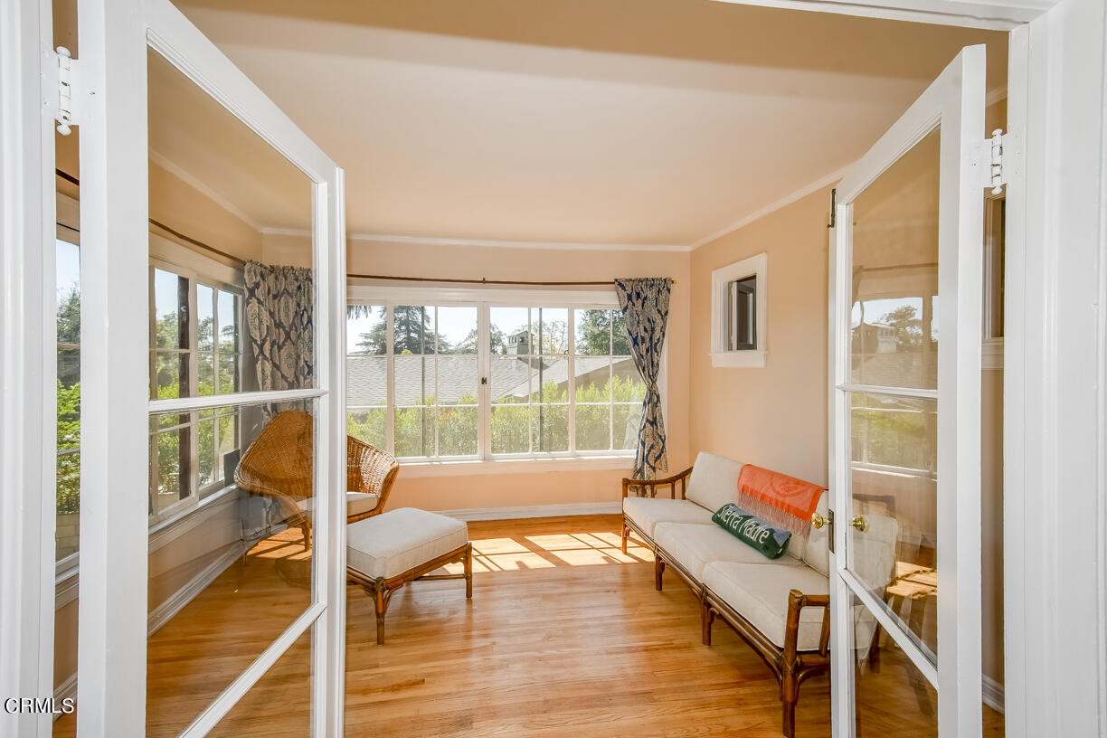 a living room with a floor to ceiling window and wooden floor