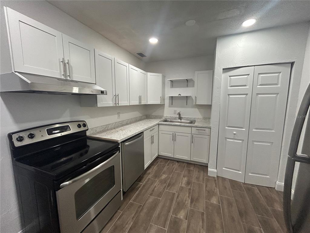 a kitchen with white cabinets stainless steel appliances and sink