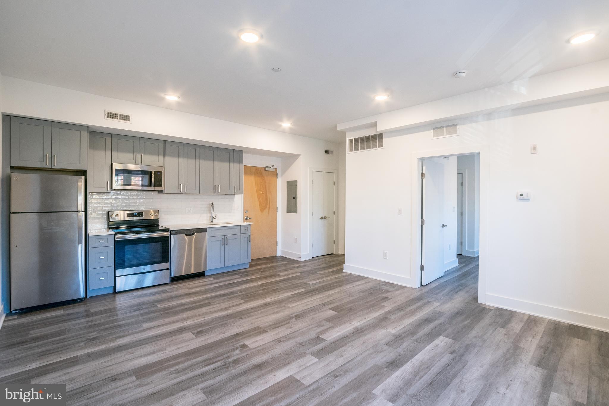 a large kitchen with a refrigerator and a stove top oven