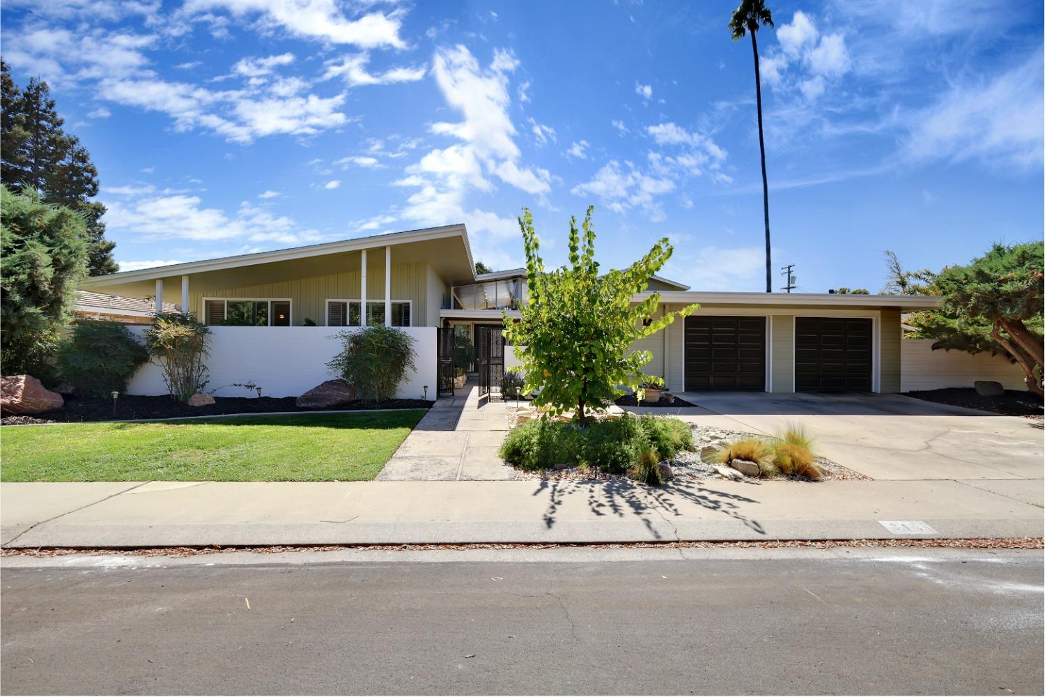 a front view of a house with a garden and outdoor seating