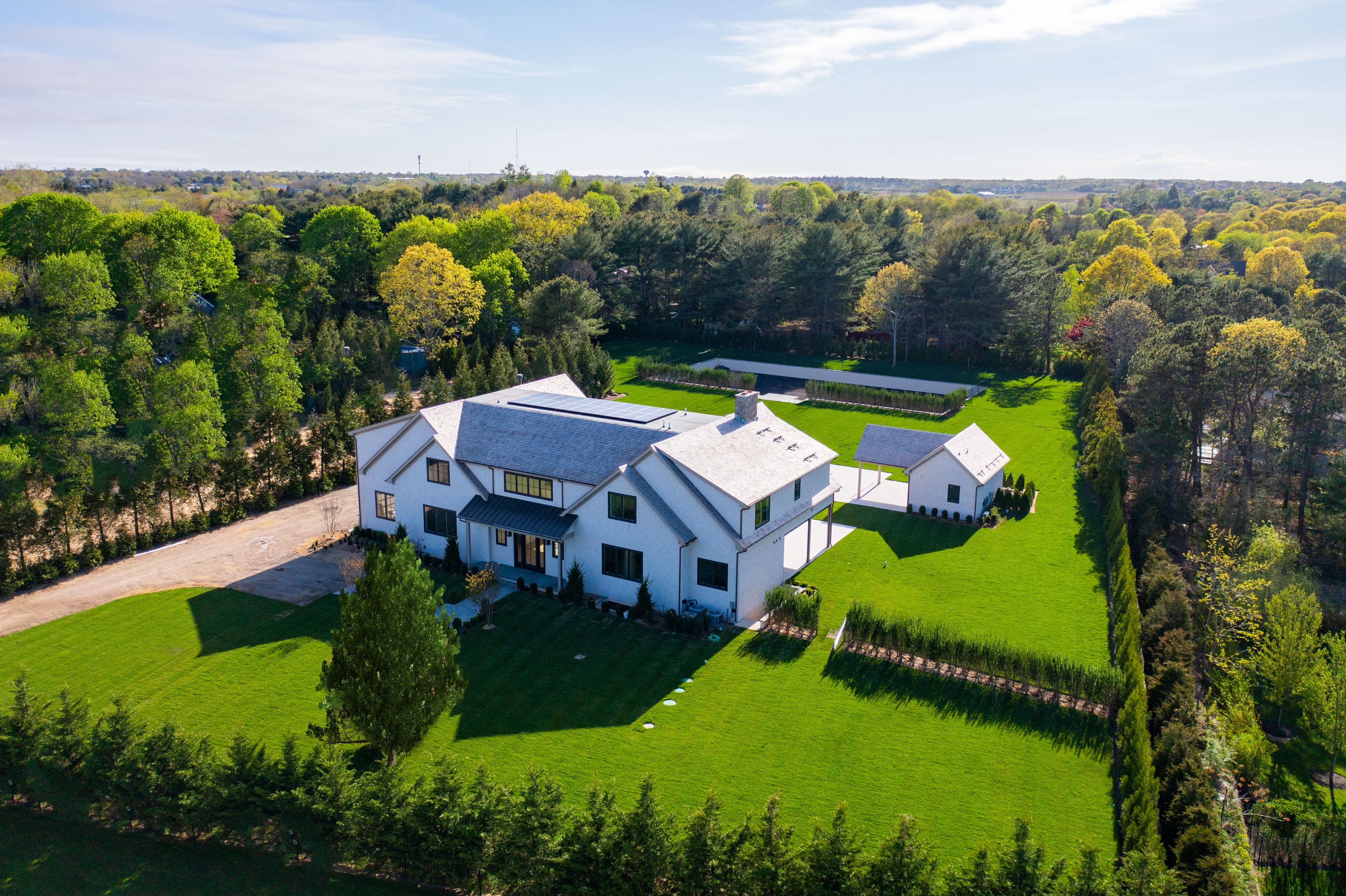 an aerial view of a house with a garden and lake view