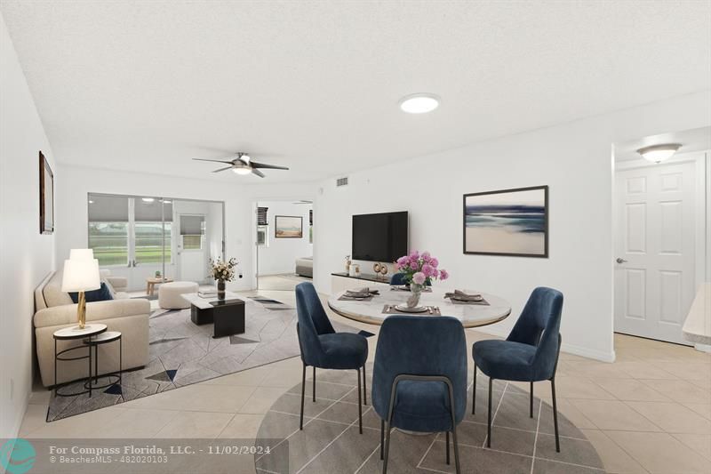 a living room with furniture a flat screen tv and a large window