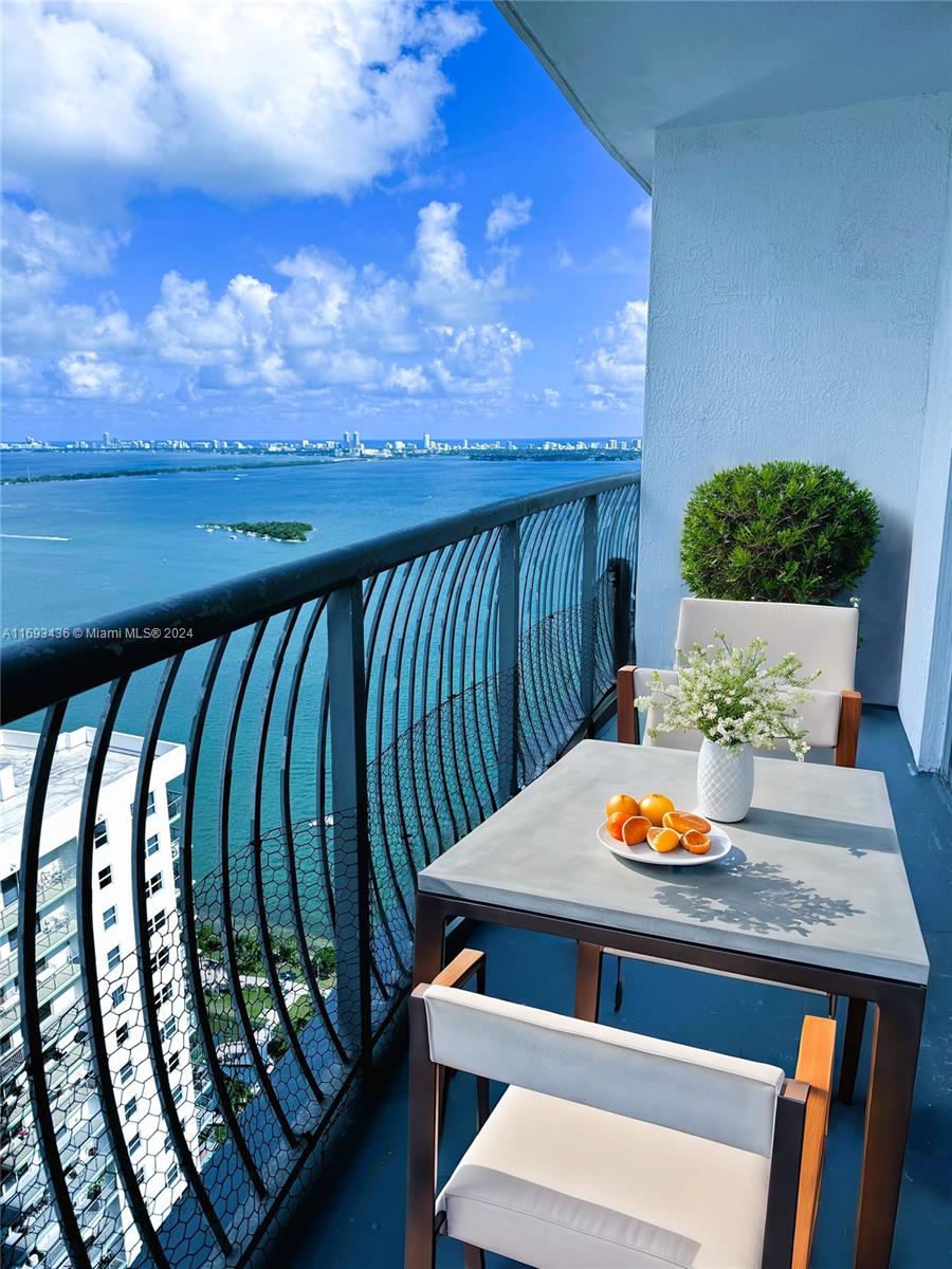 a view of a balcony with dining table and chairs