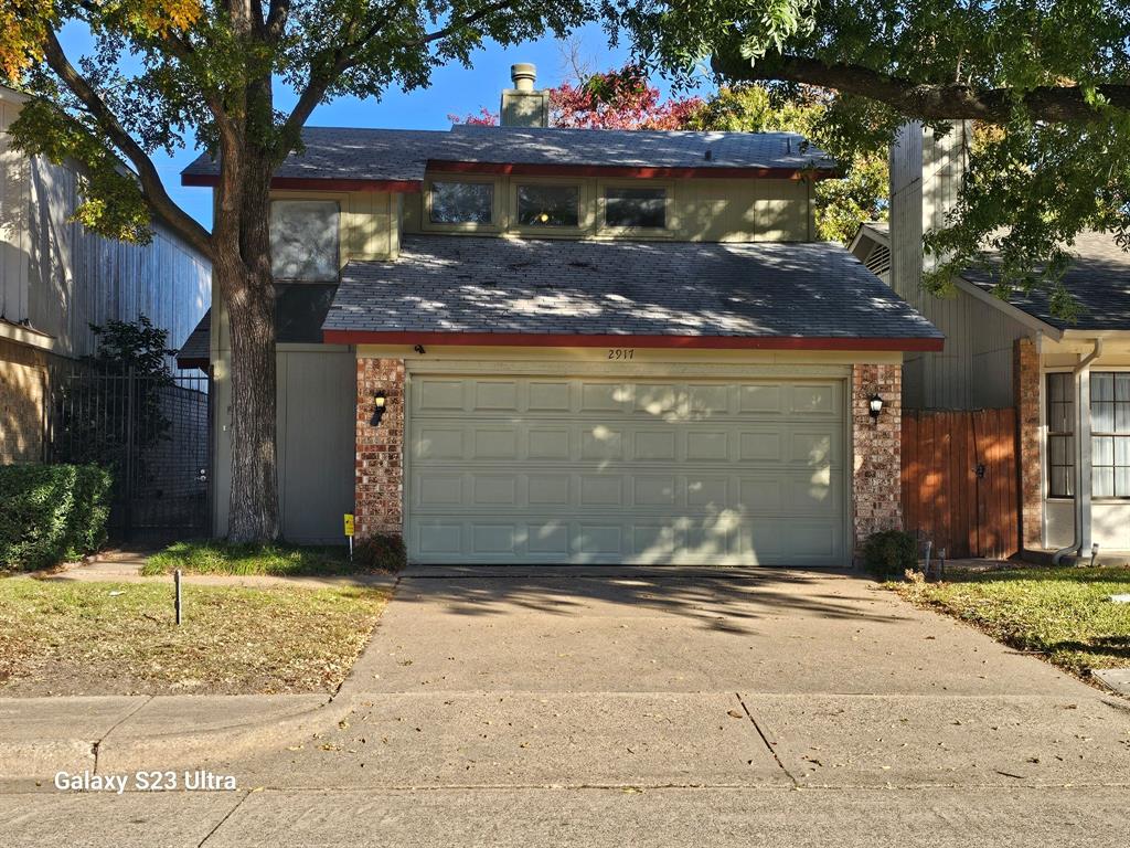 a view of a house with a tree in front of it