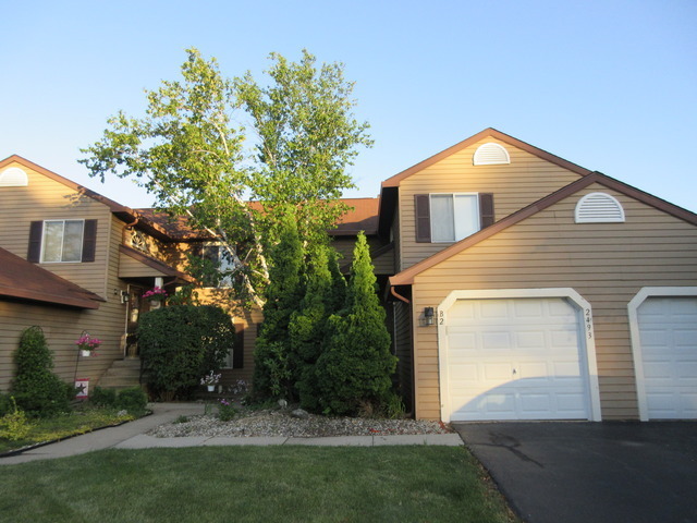 a front view of a house with a garden and trees