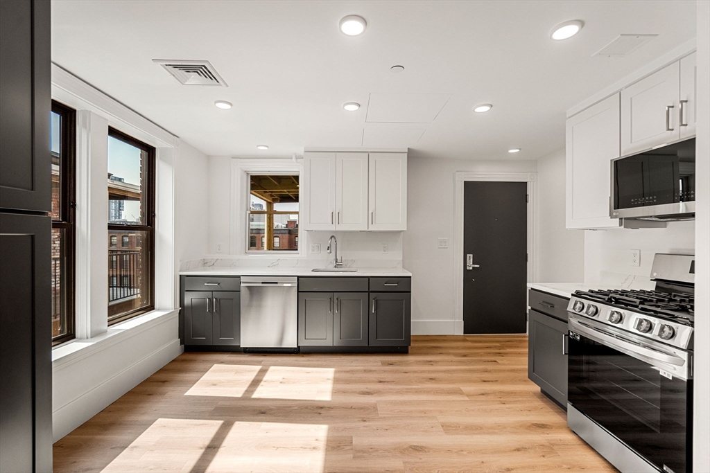 a large kitchen with stainless steel appliances granite countertop a stove and a sink