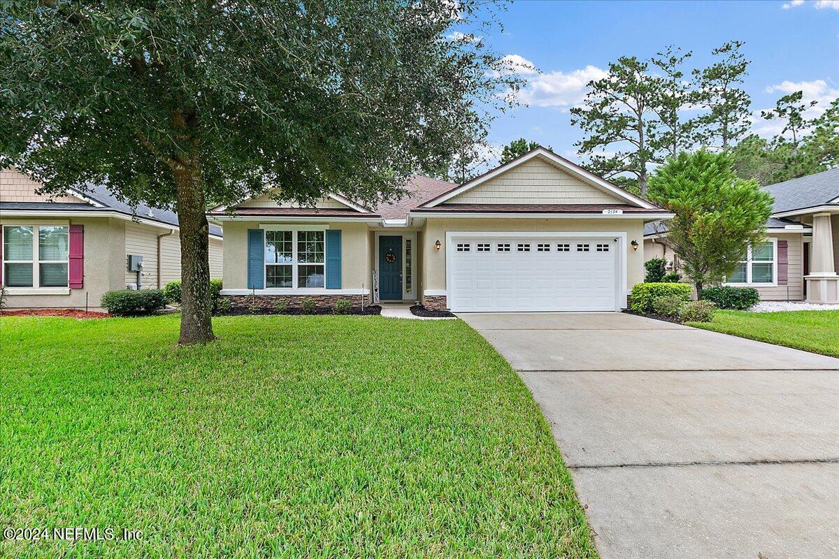 a front view of a house with a yard and garage