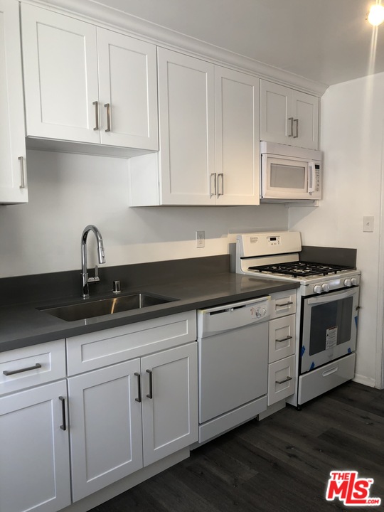 a kitchen with white cabinets and a sink