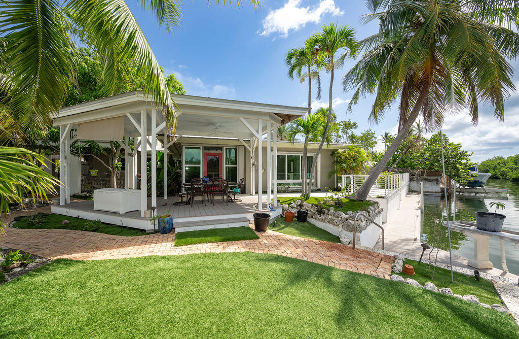 a view of a house with backyard porch and sitting area