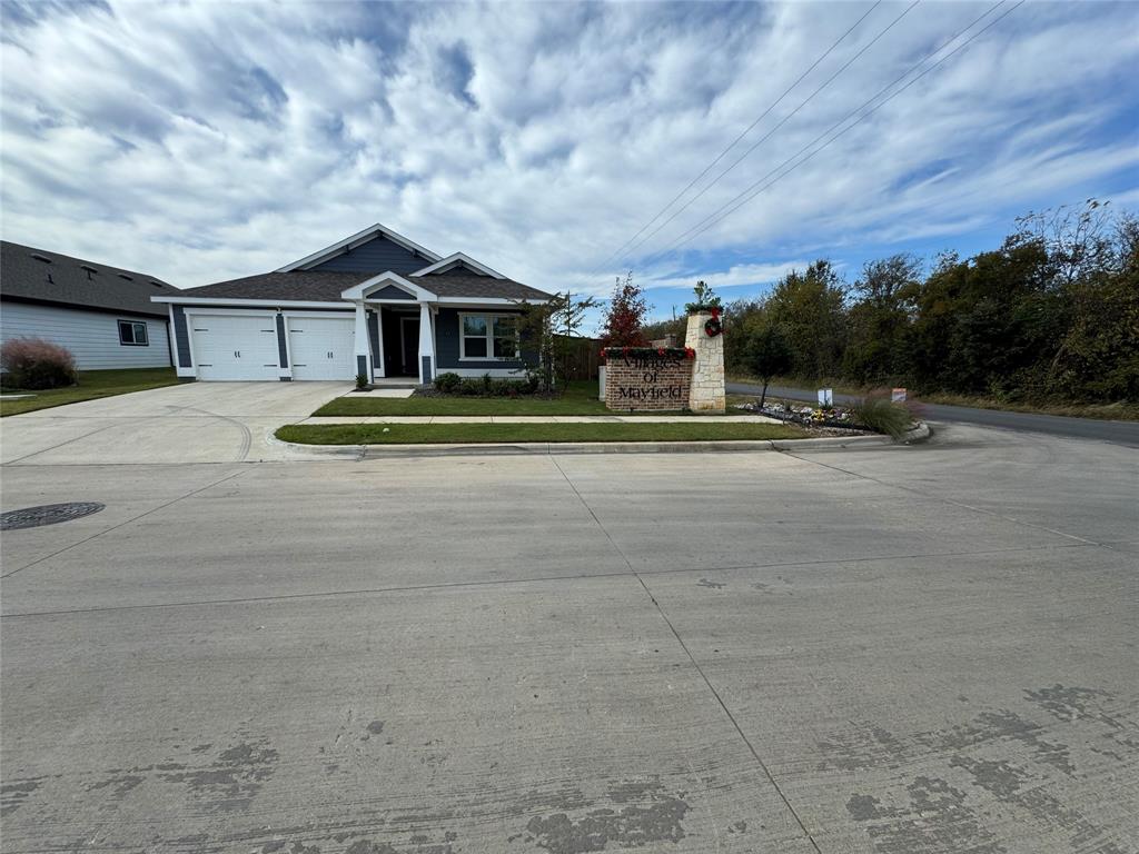 a front view of house with yard and trees in the background