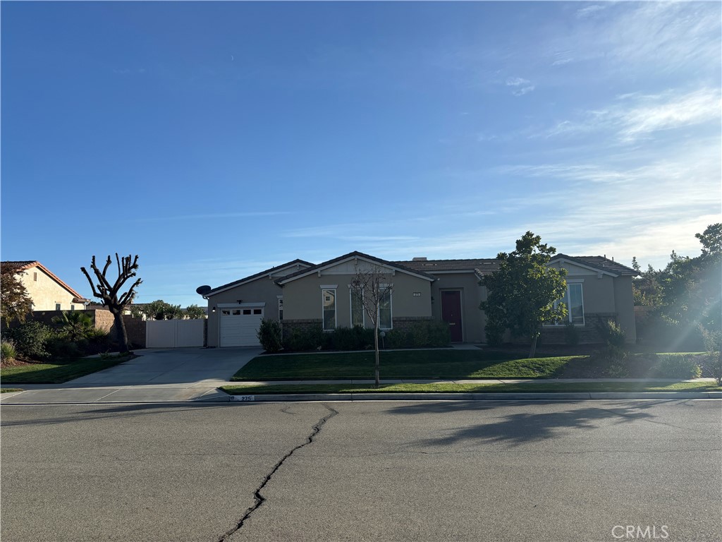 a view of a house with a yard and a large parking space