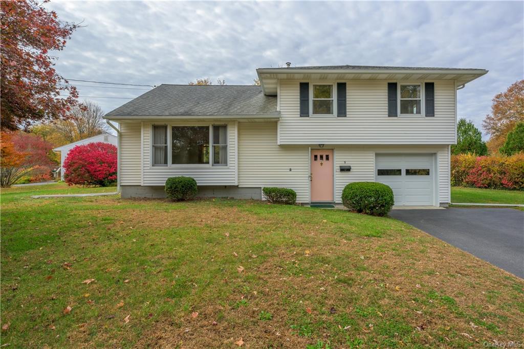 Split level home featuring a front lawn and a garage