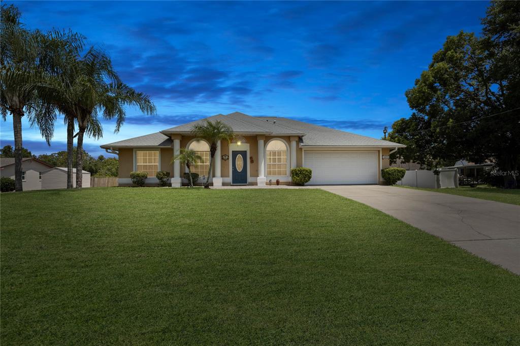 a front view of house with yard and green space