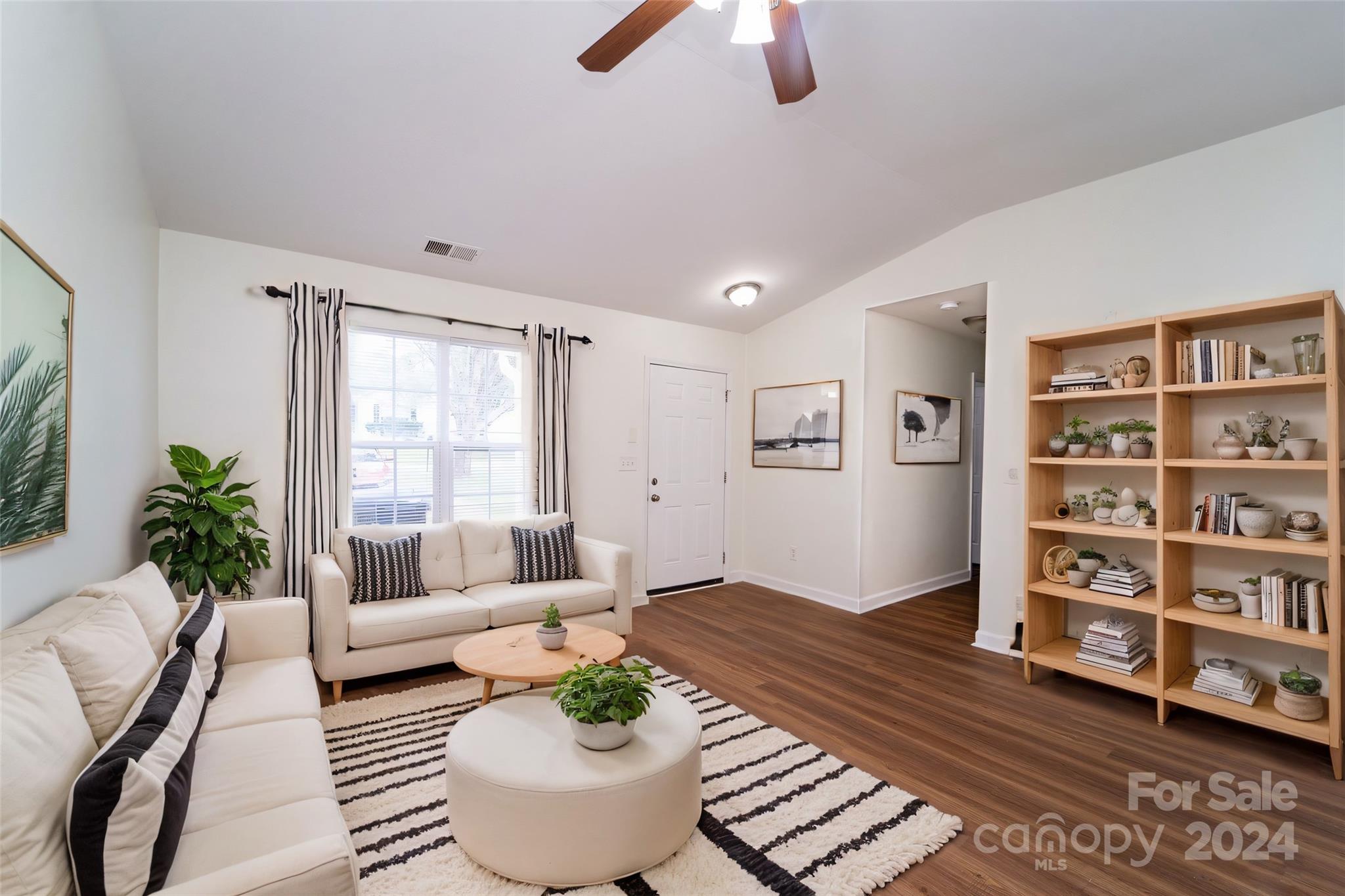 a living room with furniture and a book shelf