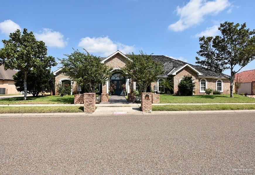 a view of a house with a big yard and large trees