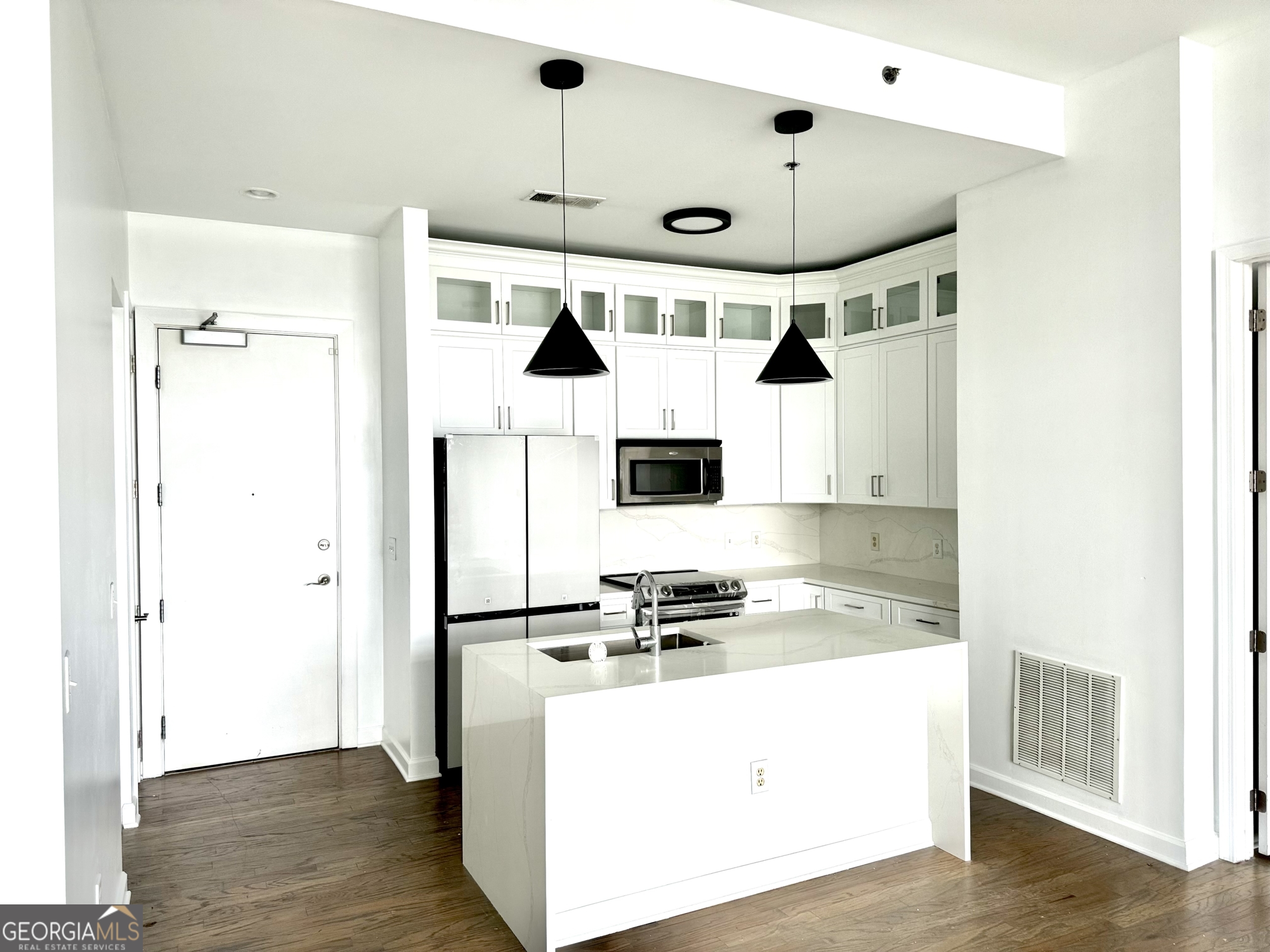 a kitchen with stainless steel appliances a refrigerator and a stove top oven