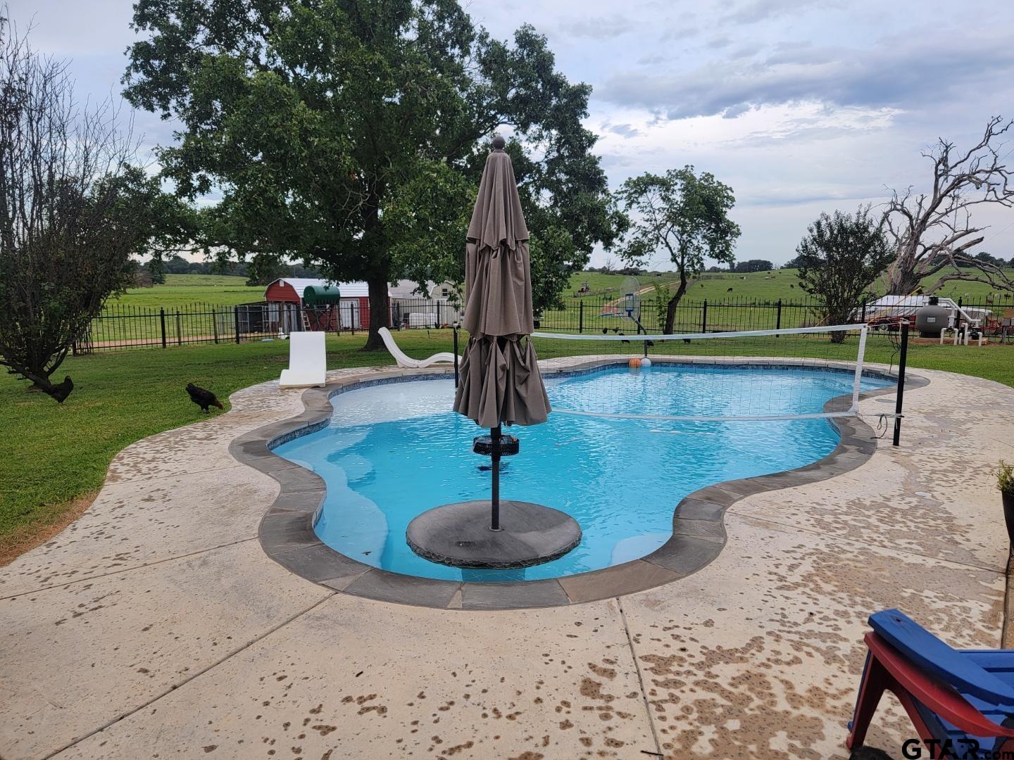 a swimming pool with outdoor seating yard and barbeque oven