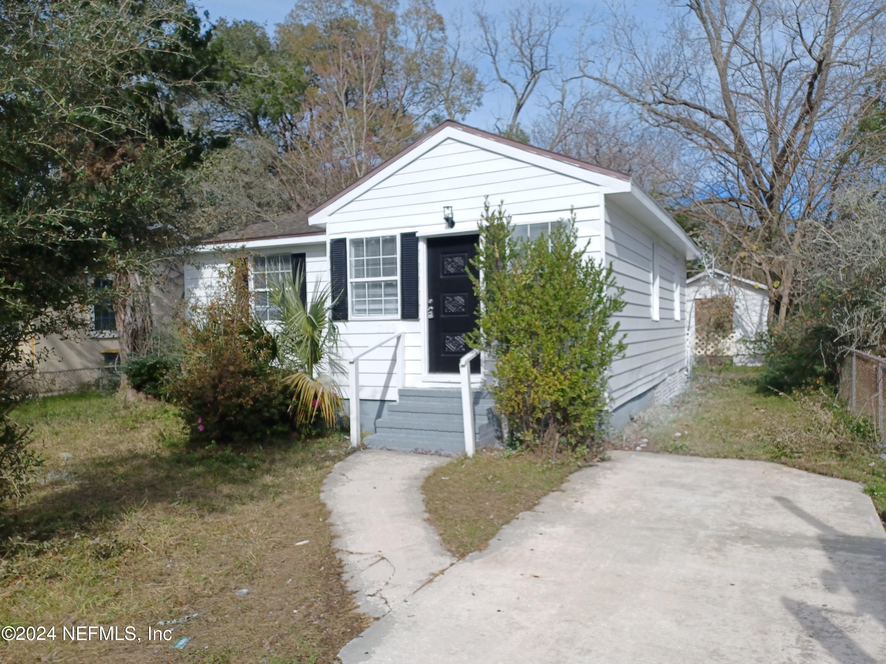 a front view of a house with a yard and trees