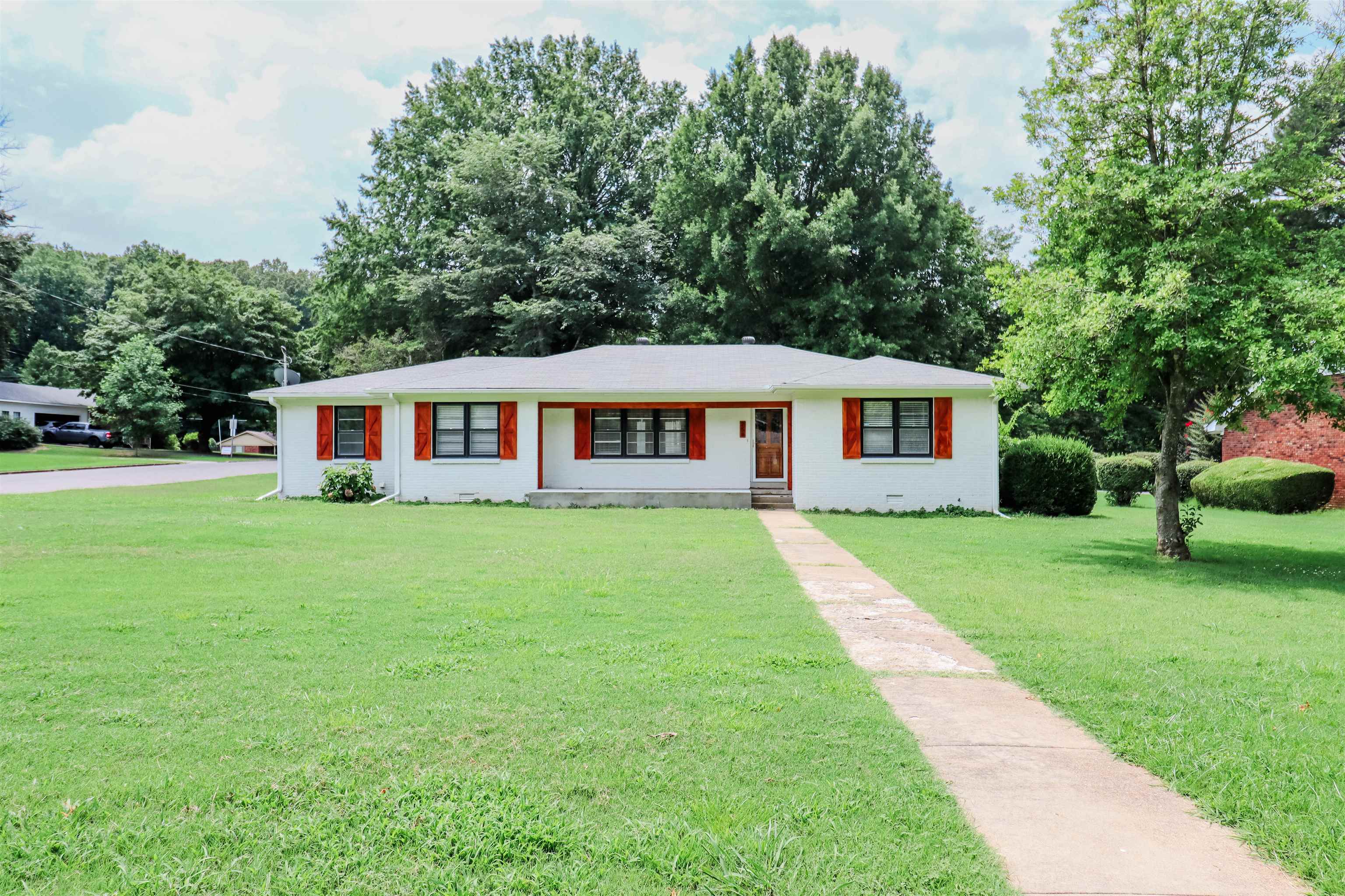 a front view of a house with a yard table and trees