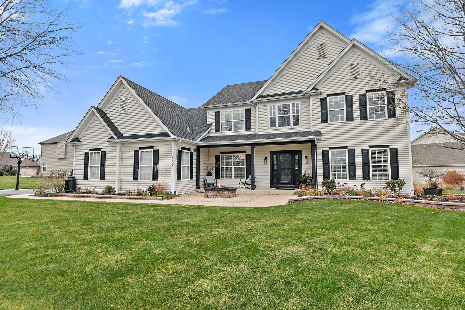 a front view of a residential houses with yard and parking space