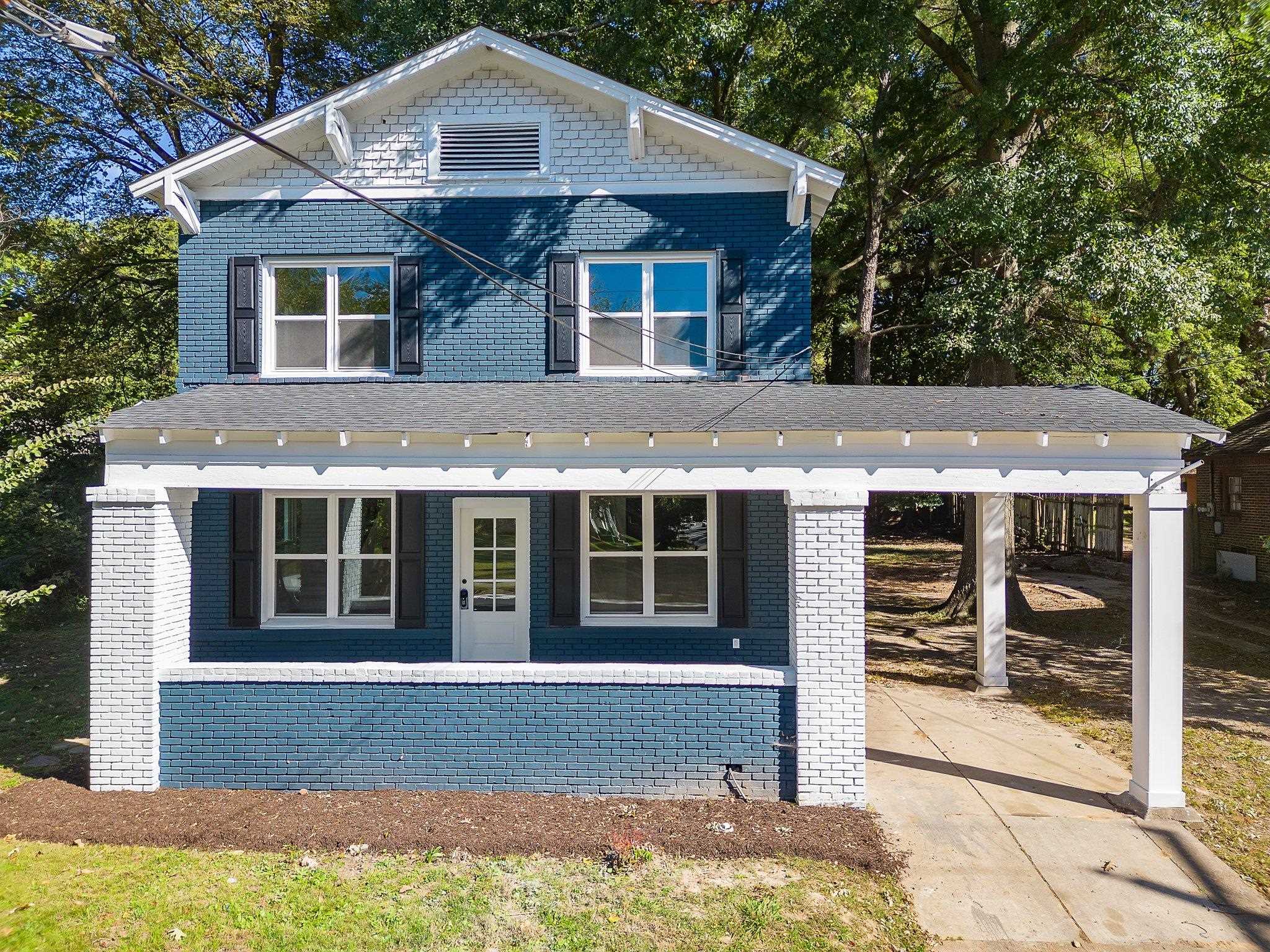 View of front facade featuring a porch and a carport