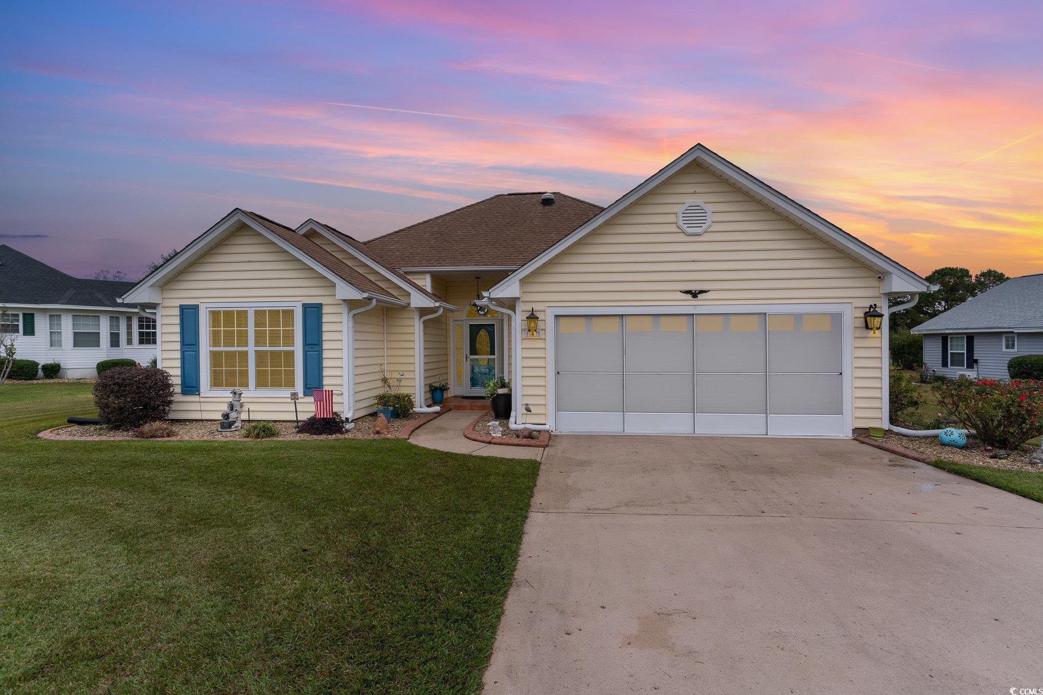 Single story home with a garage and a yard