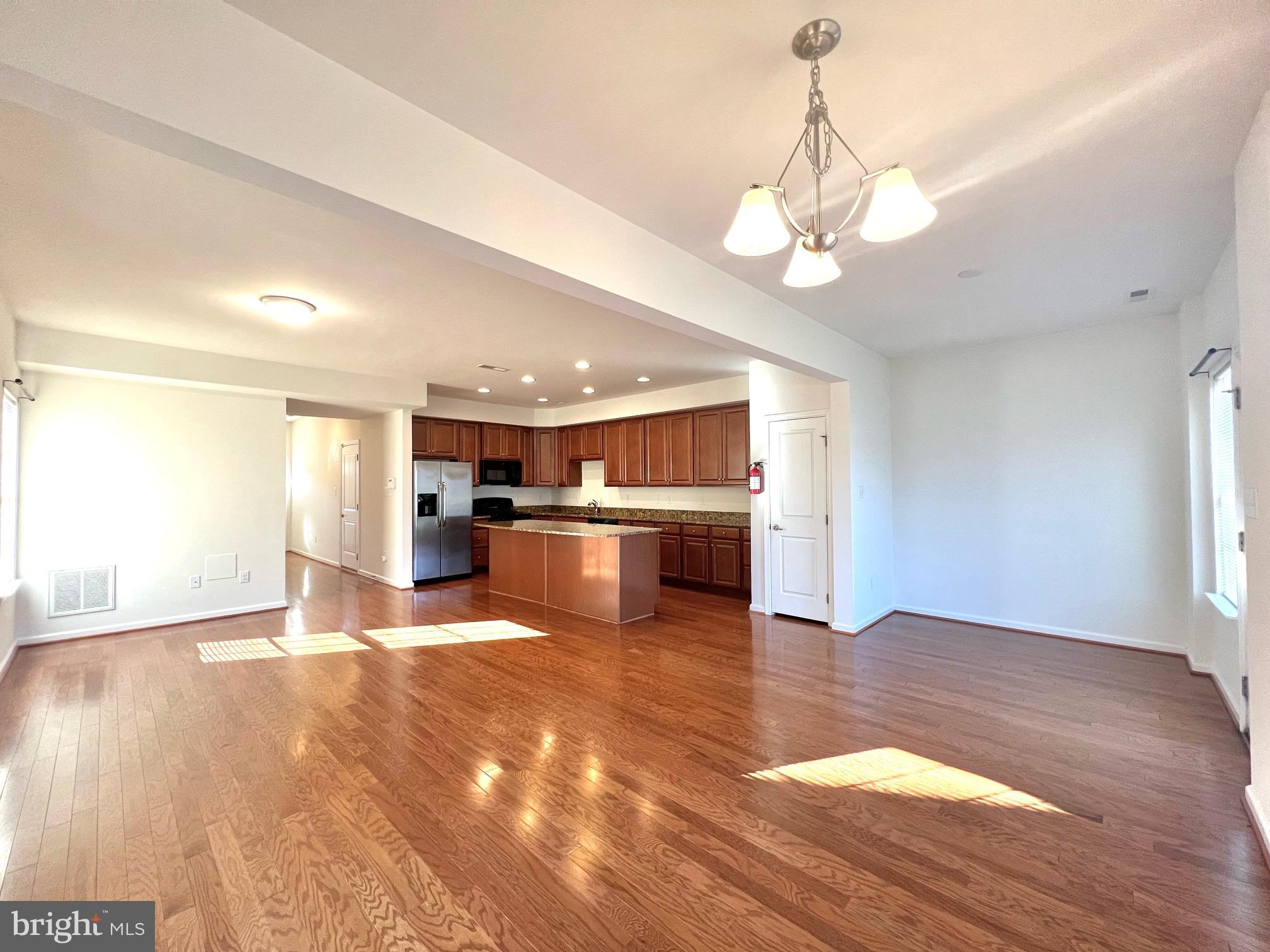 a view of kitchen with granite countertop cabinets and refrigerator