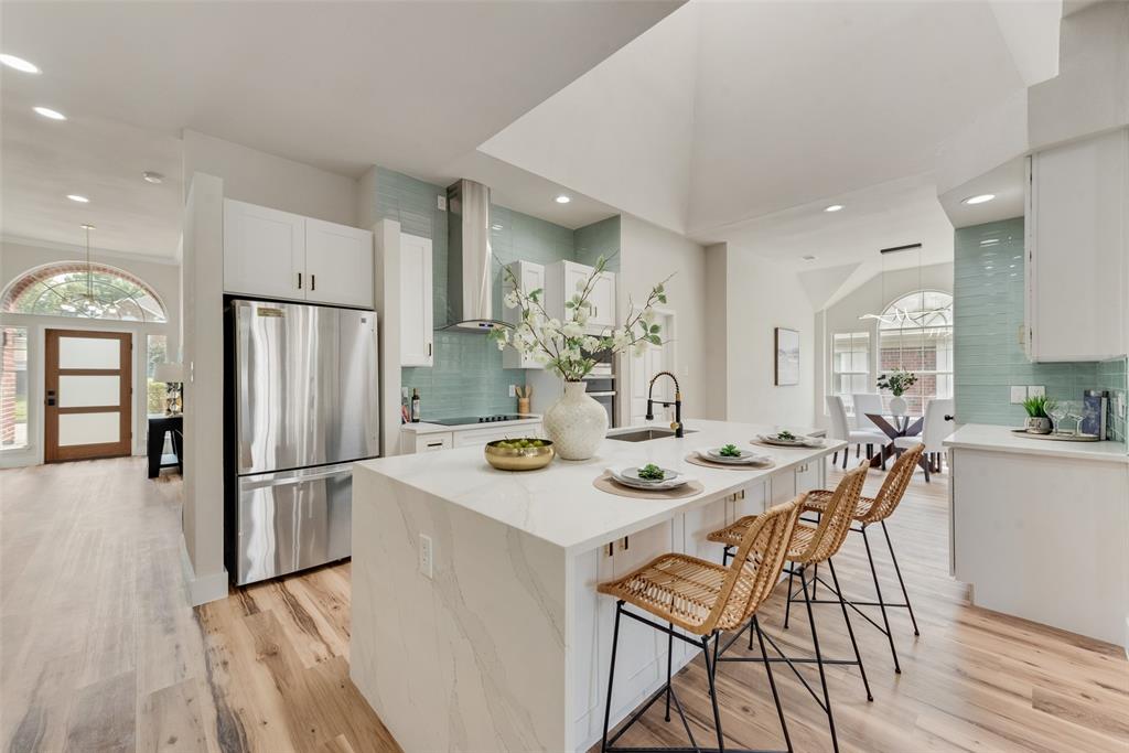 a kitchen with stainless steel appliances granite countertop a refrigerator and a stove top oven