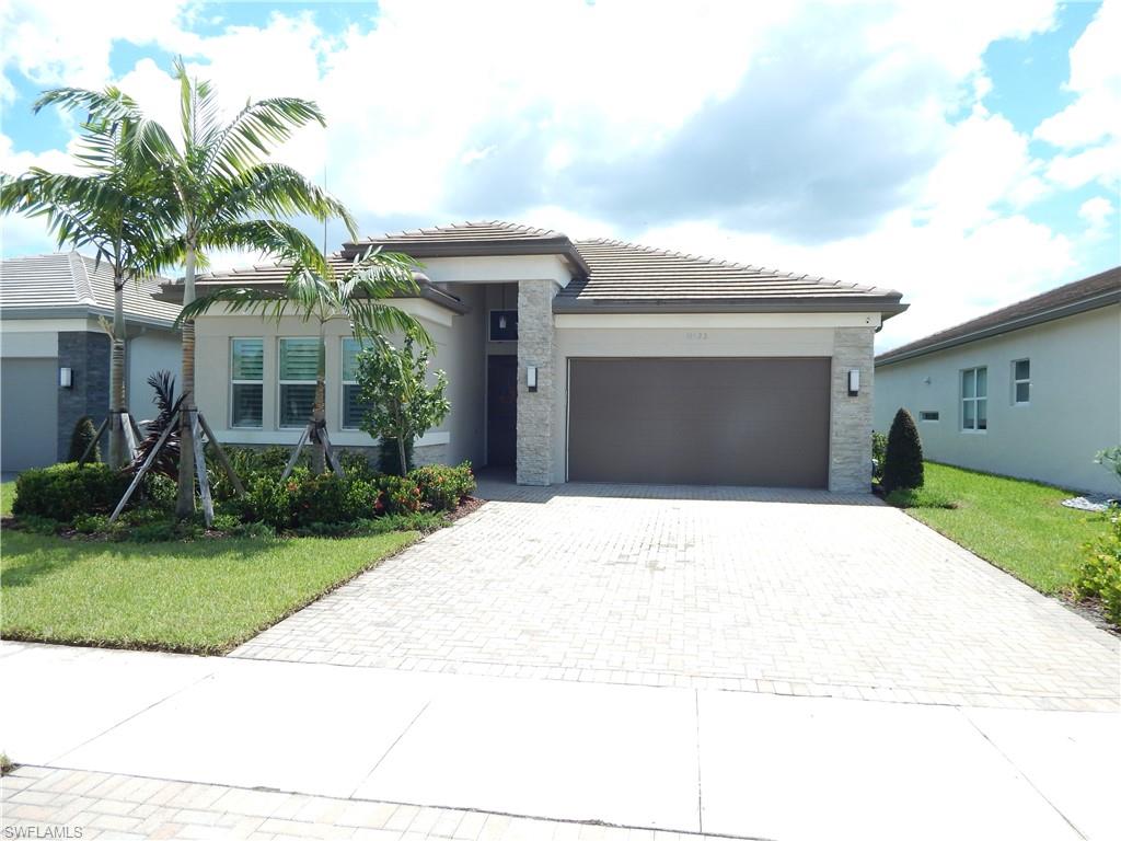 View of front of property featuring a garage and a front lawn