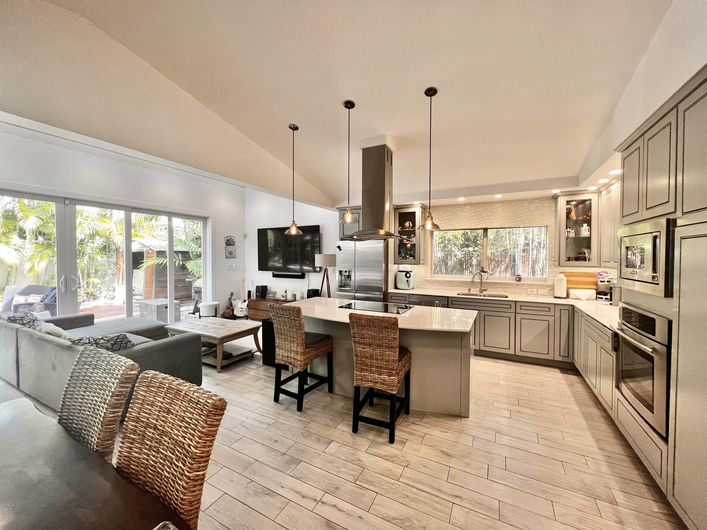 a large kitchen with a large counter top furniture stainless steel appliances and a large window