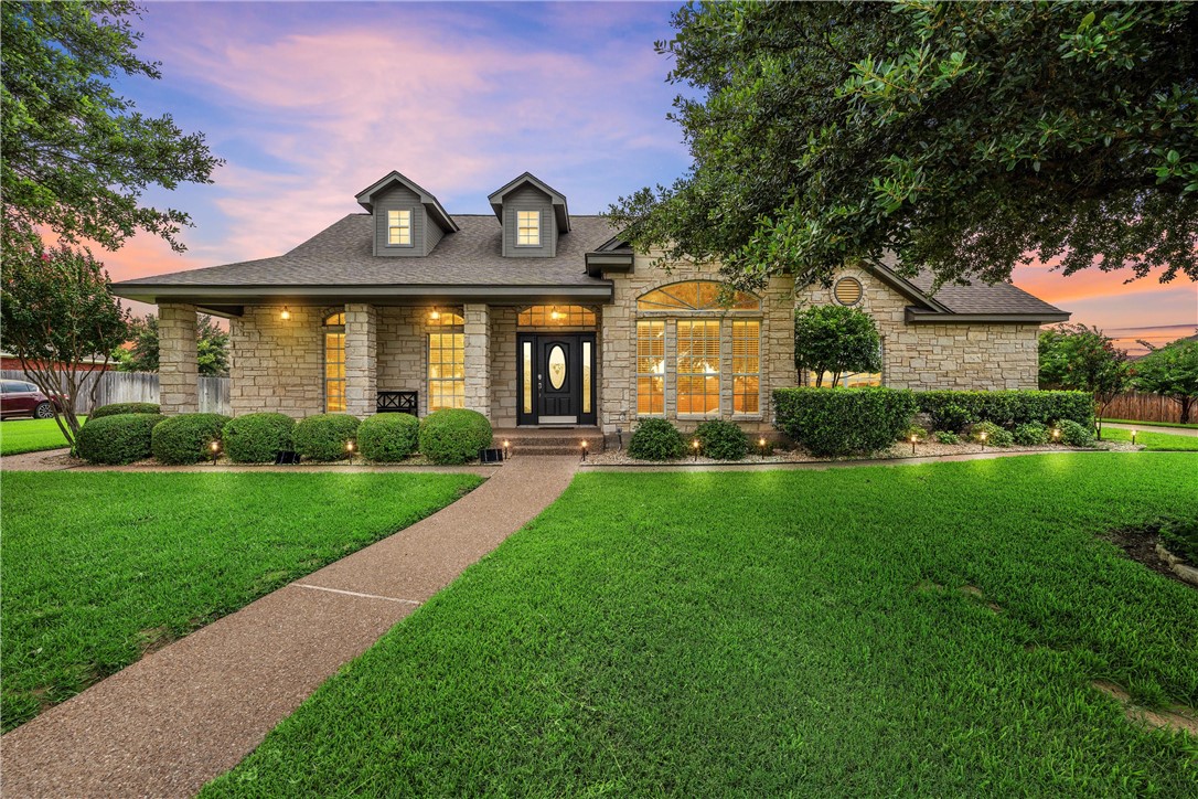 a front view of a house with a yard and potted plants