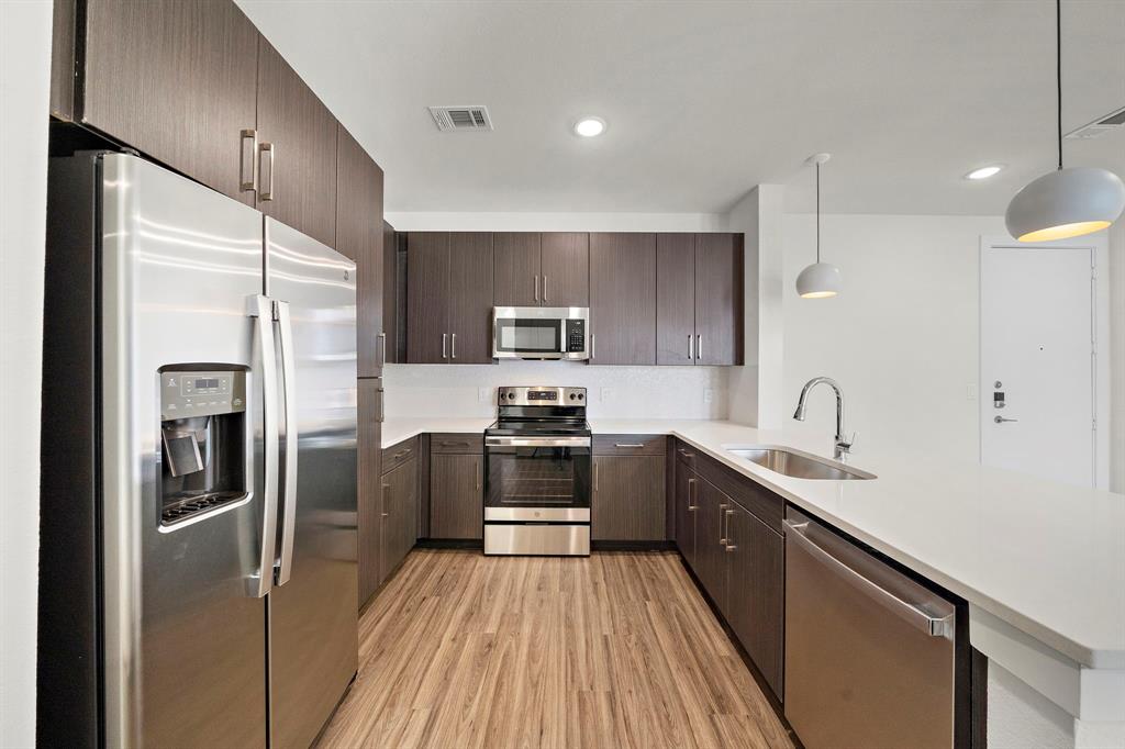 a kitchen with kitchen island granite countertop stainless steel appliances and sink