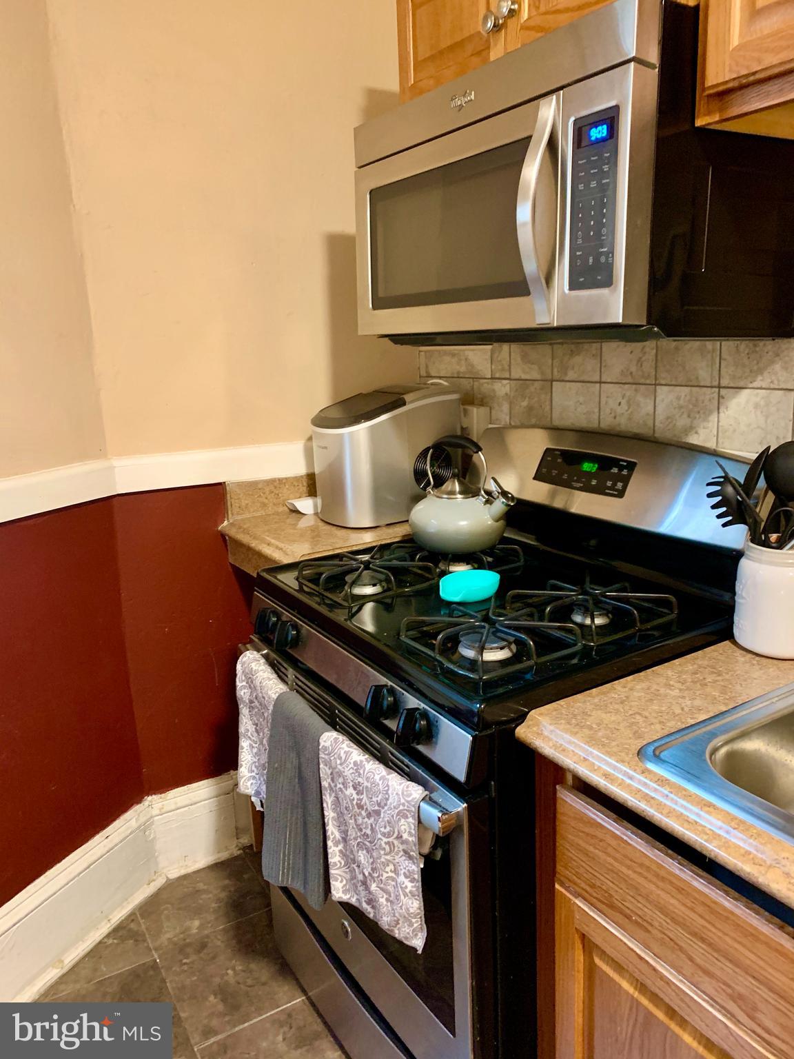 a stove top oven sitting inside of a kitchen