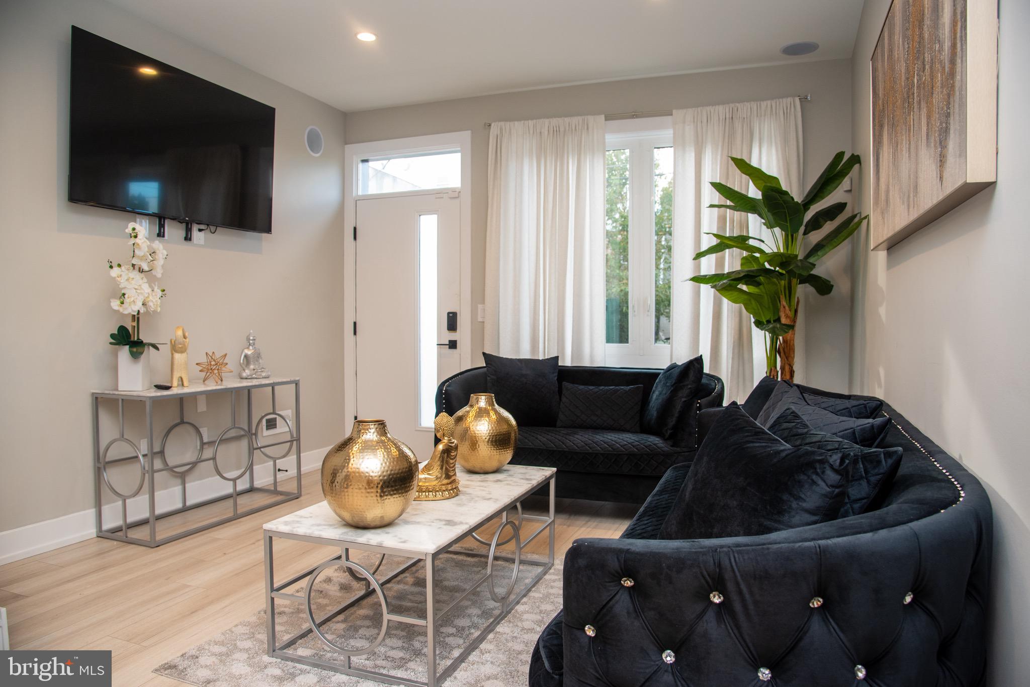 a living room with furniture a flat screen tv and a window