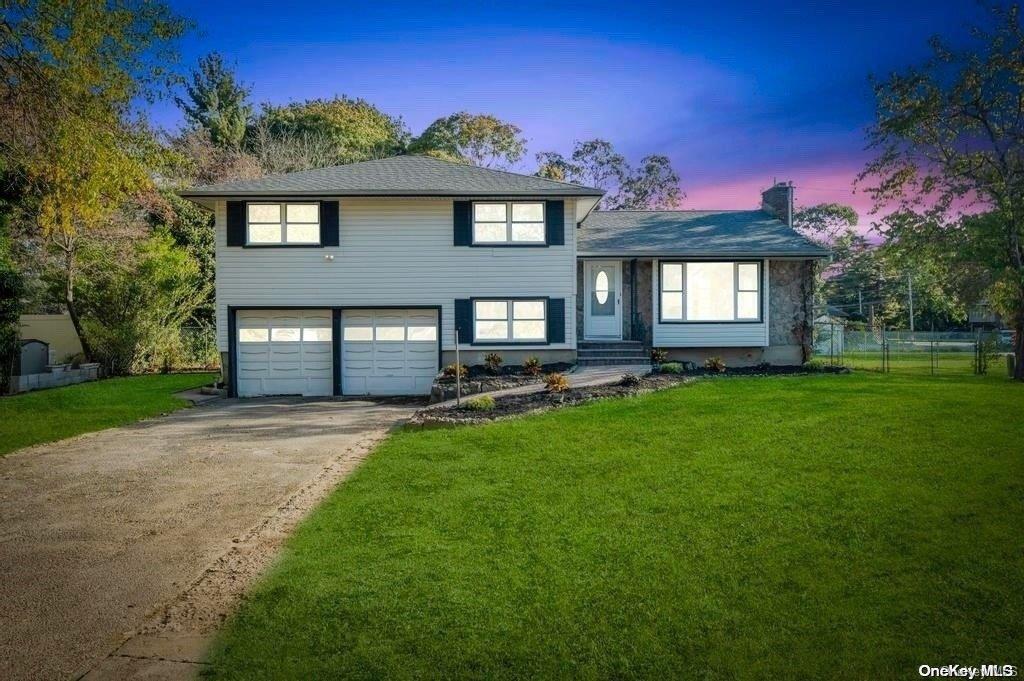 a front view of a house with a yard and garage