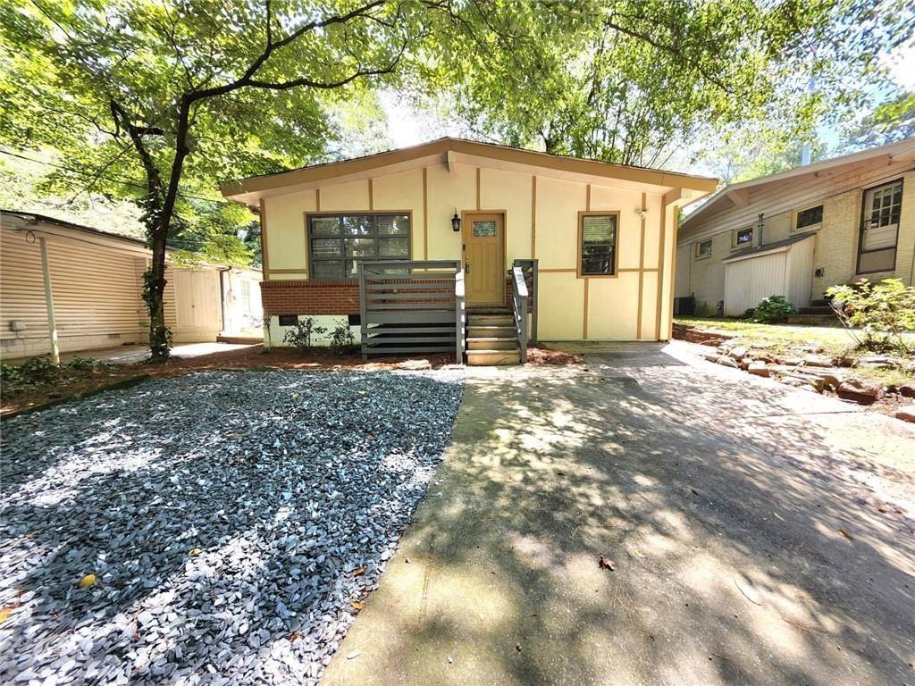 a view of a house with backyard and trees