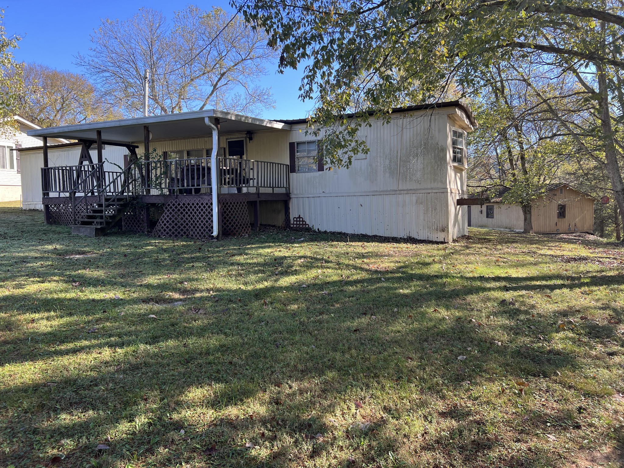 a view of a house with a big yard and large tree