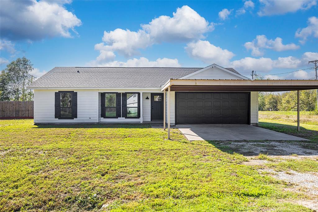 a view of a house with a yard and garage