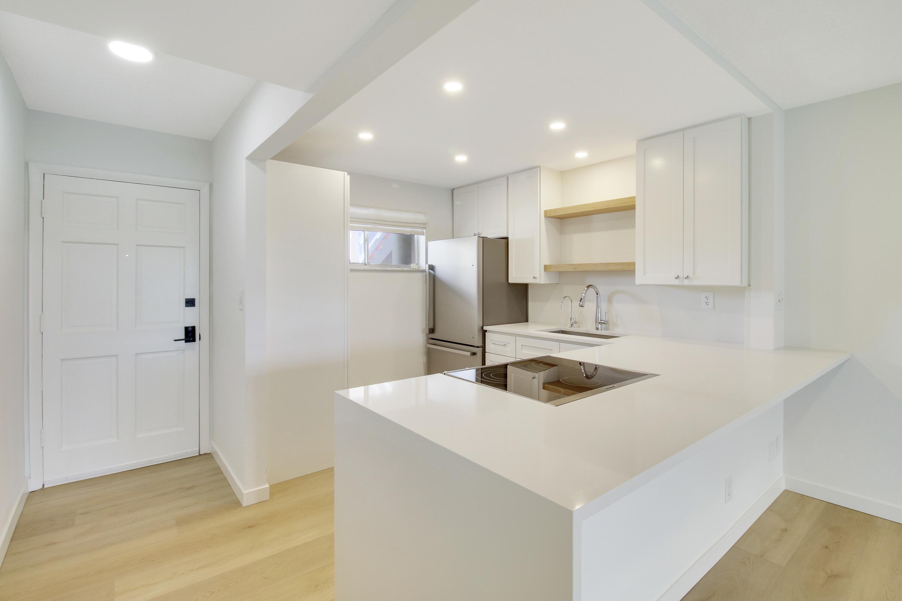 a kitchen that has a sink a refrigerator and a stove top oven