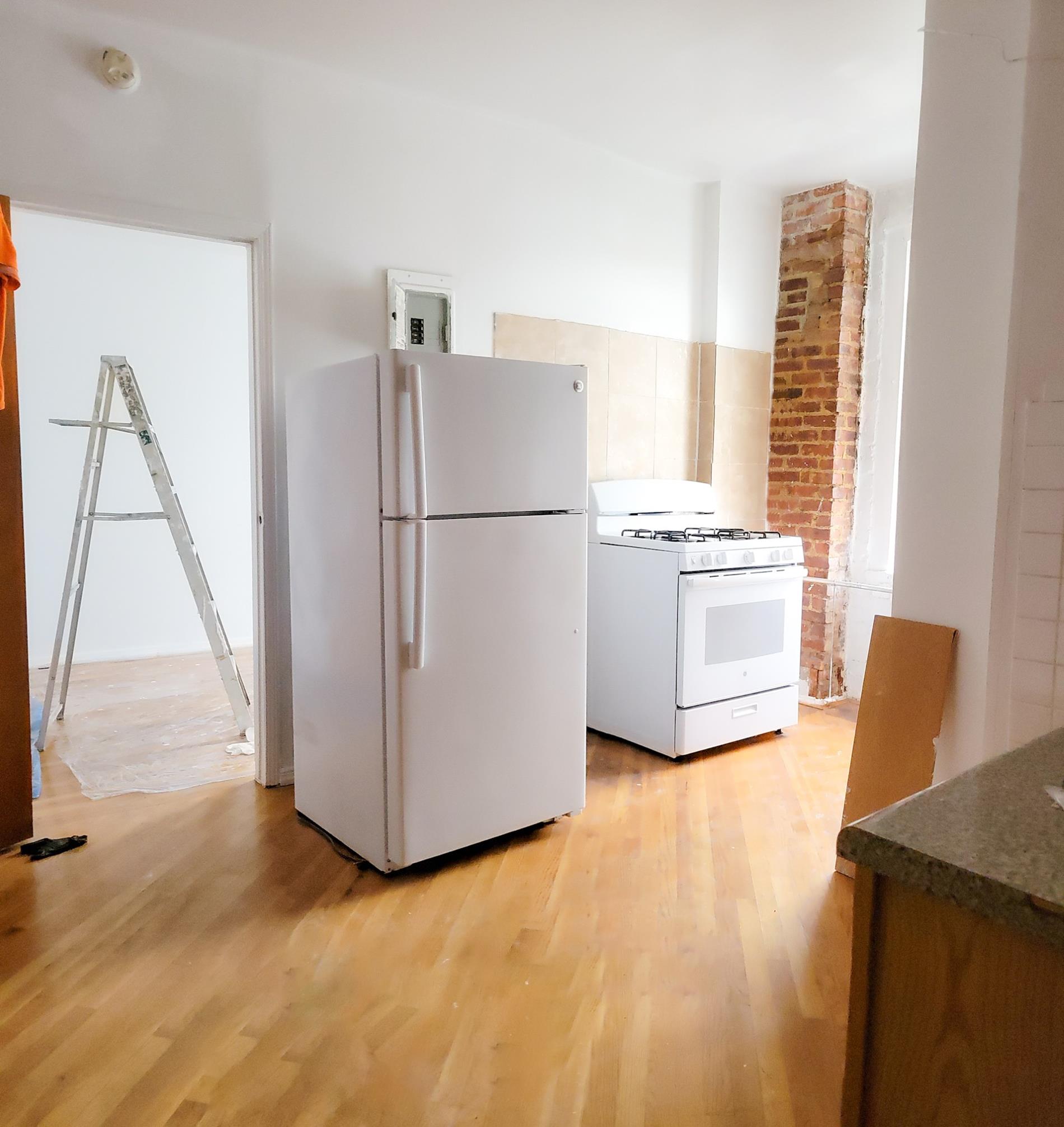 a white refrigerator freezer and a wooden floor