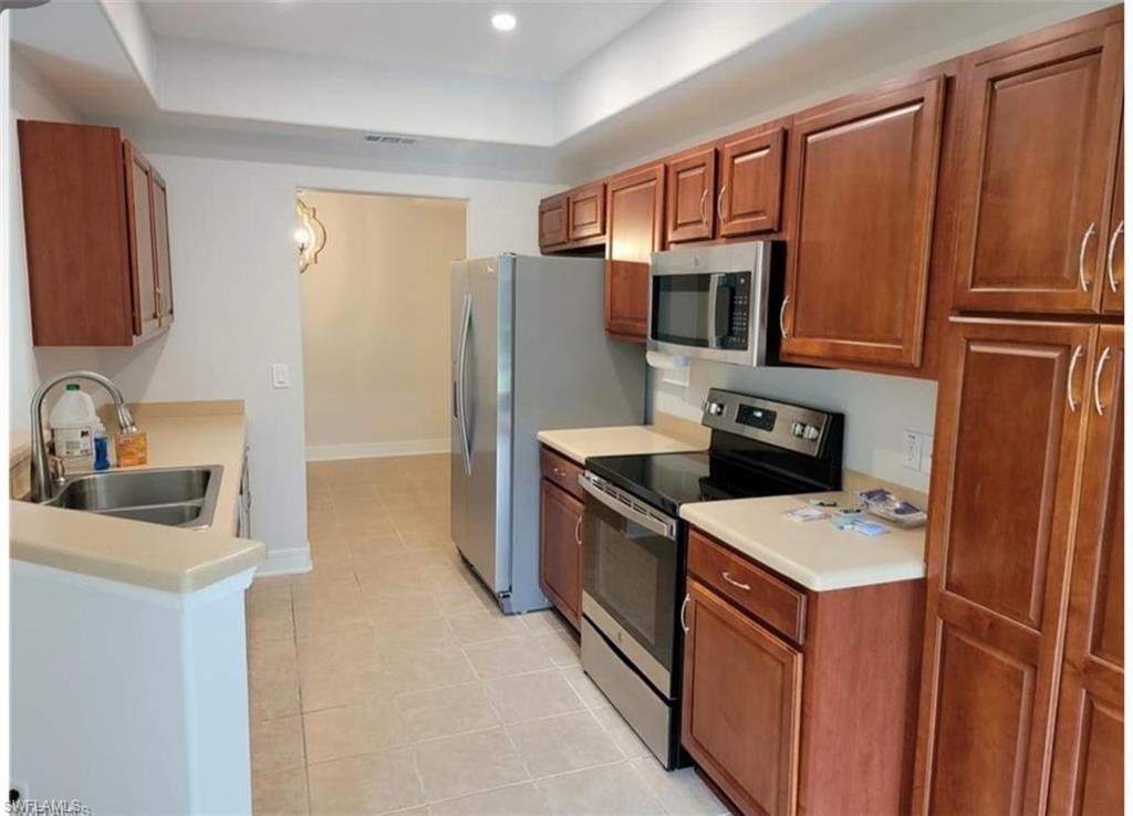 a kitchen with stainless steel appliances granite countertop a refrigerator stove microwave and sink