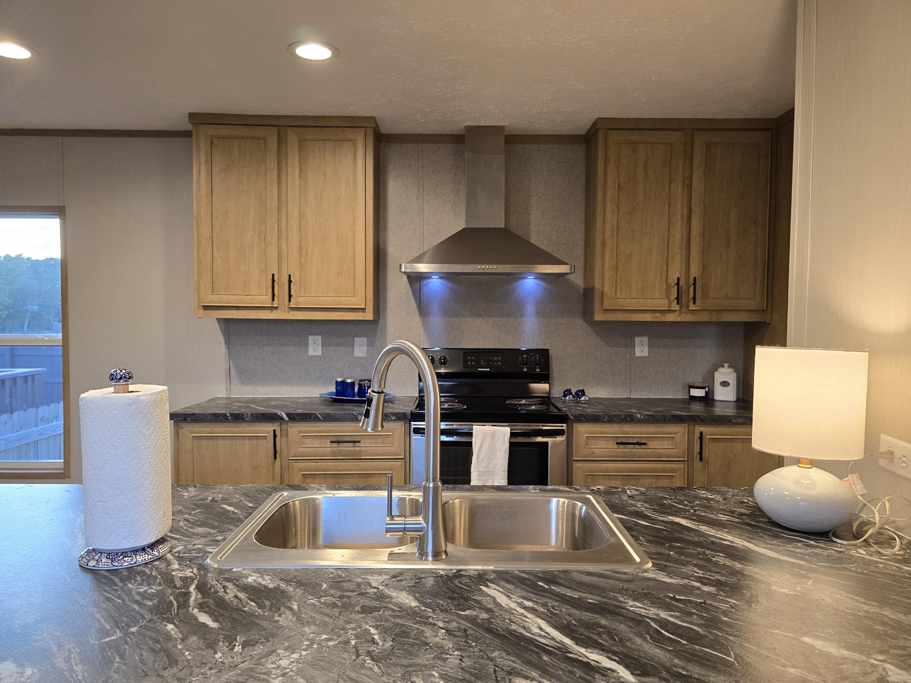 a kitchen with a sink a stove and a microwave