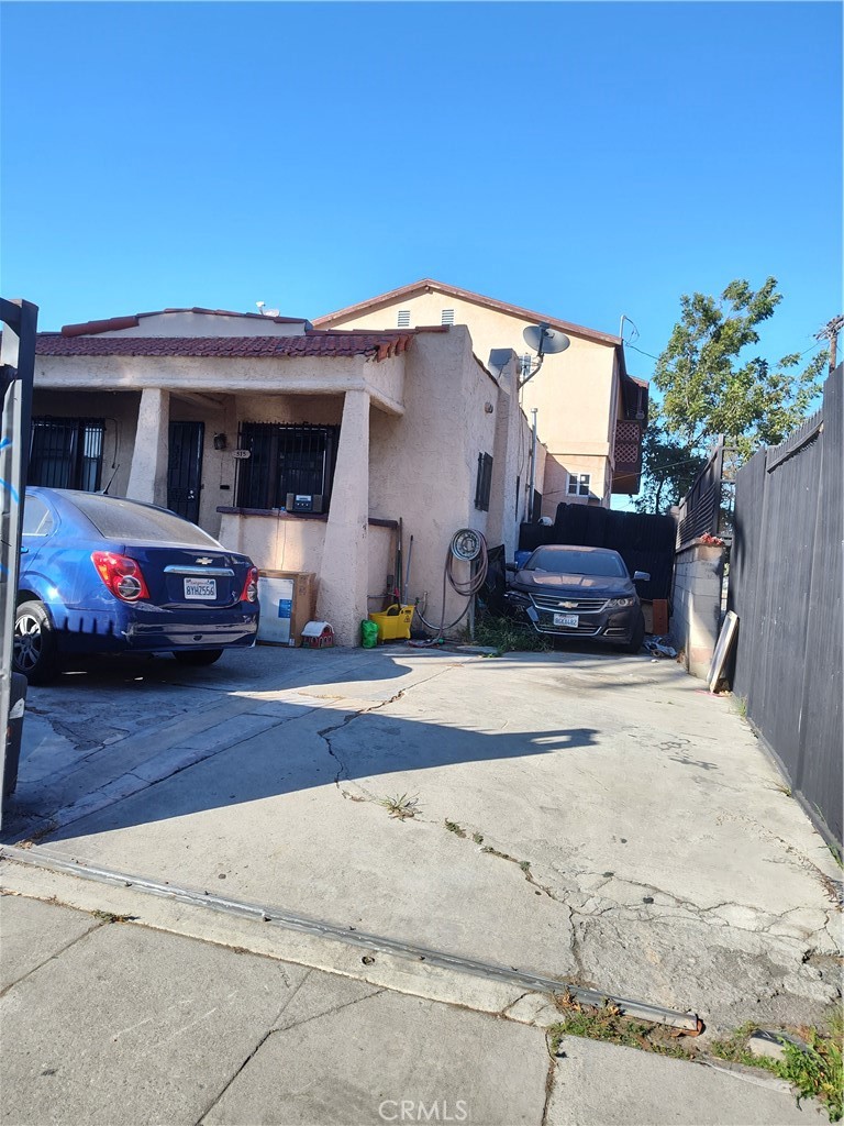 a front view of a house with cars parked