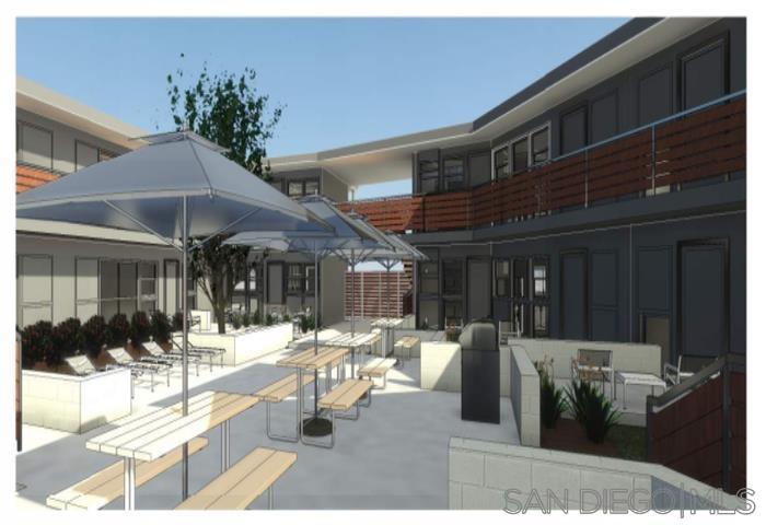 a view of the patio with dining table and chairs under an umbrella