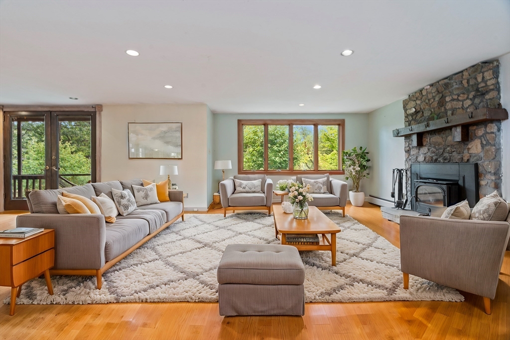 a living room with fireplace furniture and a large window