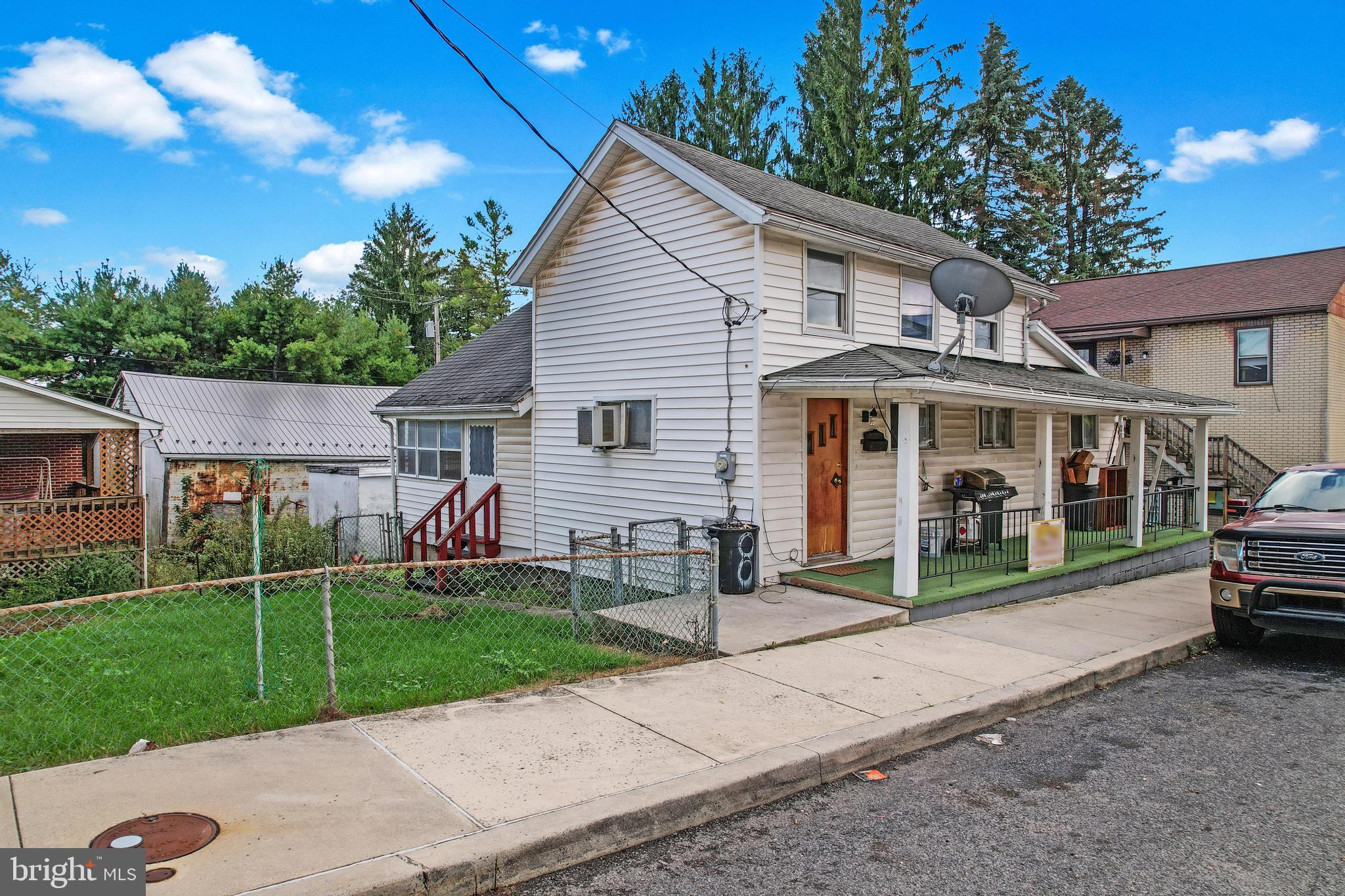 a view of a house with a yard and sitting area